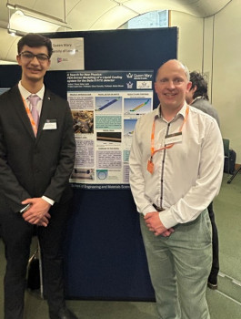 Dhyey (left) and Prof Oliver Fenwick (right) standing near the poster